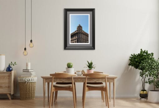 The golden sunlit facade of this charming framed picture compliments perfectly the neutral tones of this modernistic dining room, where a few green plants add a natural touch to the architectural landscape.